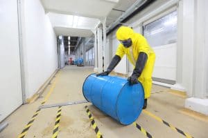 technician rolling the barrel with toxic substance